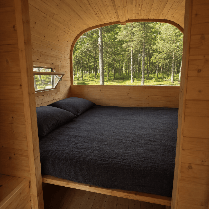 Espace nuit du pod de camping avec couchage double et vue sur la nature.